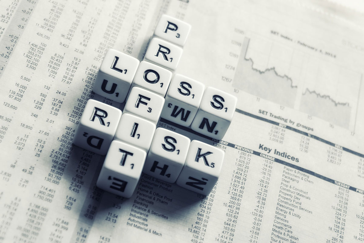 dice on financial newspaper spelling profit, loss, risk